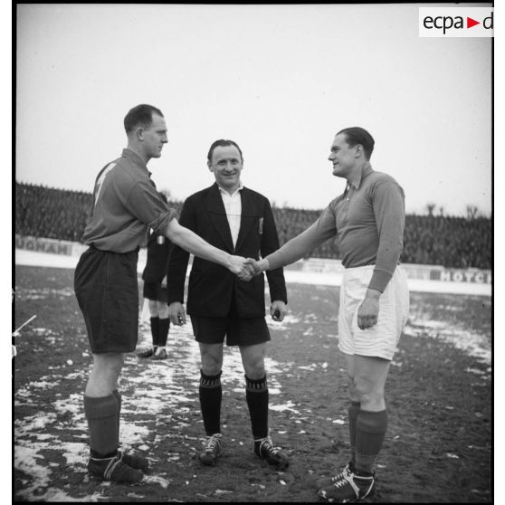 Poignée de main entre les capitaines des équipes militaires de football française et anglaise lors d’un tournoi au Parc des Princes à Paris.