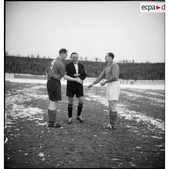 Avant le match, les capitaines des équipes militaires de football française et anglaise échangent une poignée de mains.