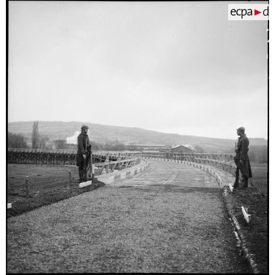 Deux sentinelles de la 2e armée montent la garde sur un pont de bois.