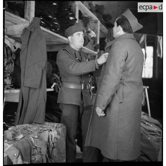 Un soldat perçoit une capote dans un centre de l'intendance.