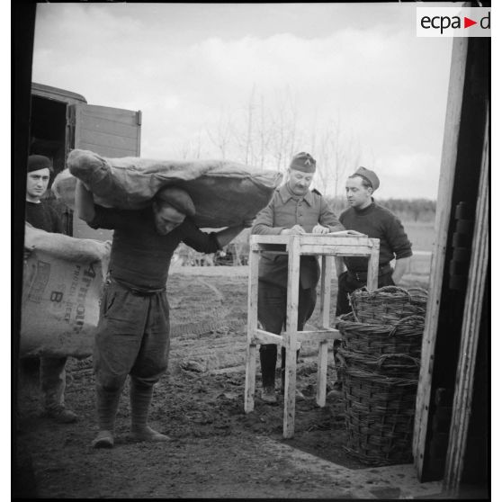 Des soldats déchargent un camion dans un centre de l'intendance de la 2e armée.