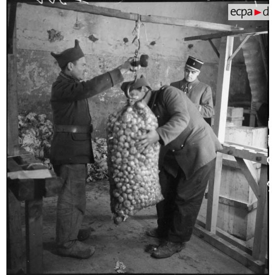 Des soldats pèsent des sacs de denrées dans un centre de l'intendance de la 2e armée.