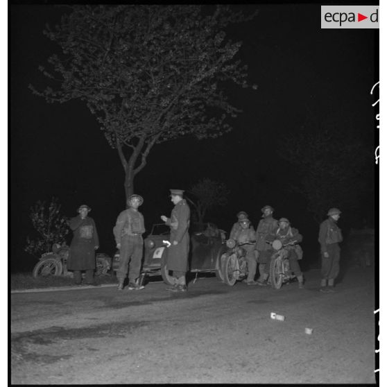 De nuit un véhicule et des deux-roues d'une colonne motorisée de la BEF sont à l'arrêt