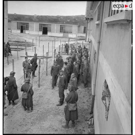 Photographie de groupe en plongée de prisonniers allemands rassemblés dans un camp.