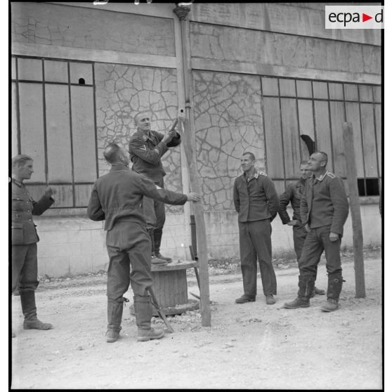 Photographie de groupe d'aviateurs allemands qui mettent en place des barbelés dans un camp de prisonniers du secteur de la 2e armée.