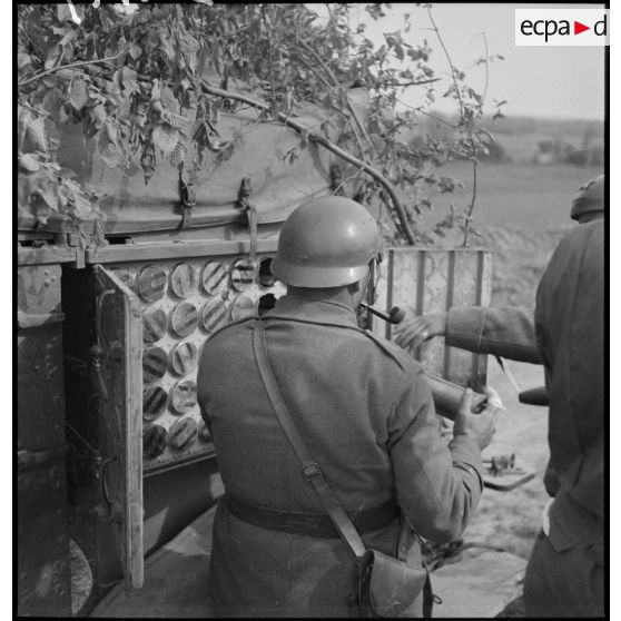 Un artilleur extrait des obus d'un caisson à munitions d'une autocanon de 75 mm CA M1913/1934.