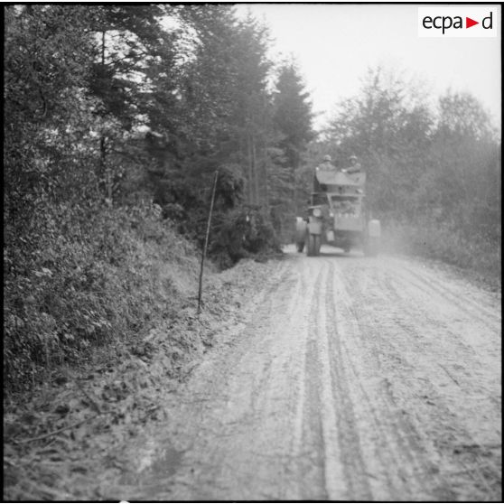 Une automitrailleuse de découverte, AMD Laffly 50, appartenant peut-être à la 3e division légère de cavalerie (DLC), armée à l'arrière d'une mitrailleuse de 8 mm modèle 1914, progresse sur un chemin de Moselle.