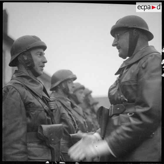 Le chef de corps décore de la croix de guerre 1939 des hommes de son bataillon lors de la prise d'armes à Magny.