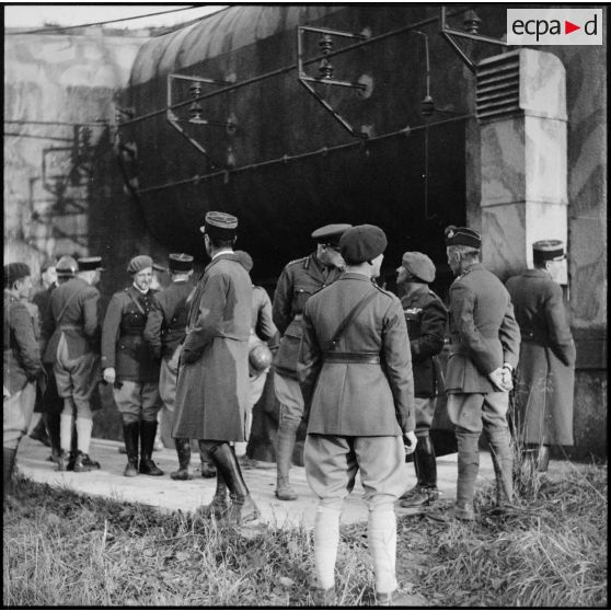 Photographie de groupe d'officiers français et britanniques devant l'entrée à munitions du Mont des Welches.