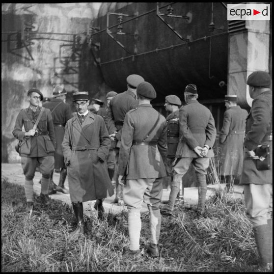 Photographie de groupe d'officiers français et britanniques devant l'entrée à munitions du Mont des Welches.
