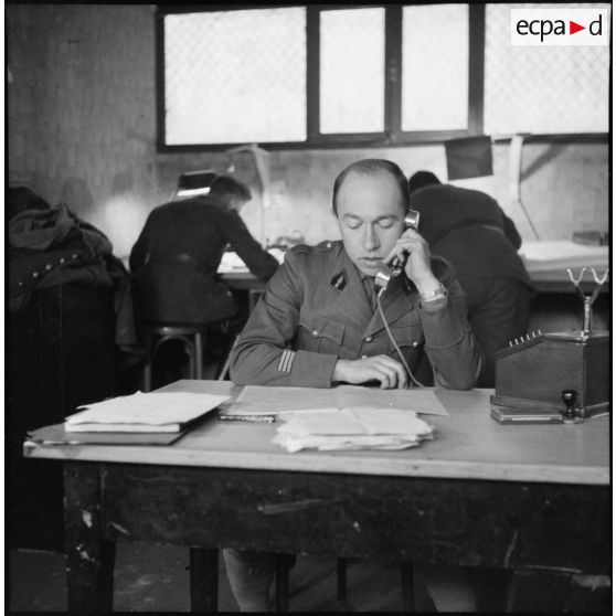 Portrait d'un capitaine de la 3e armée qui répond au téléphone à son bureau.