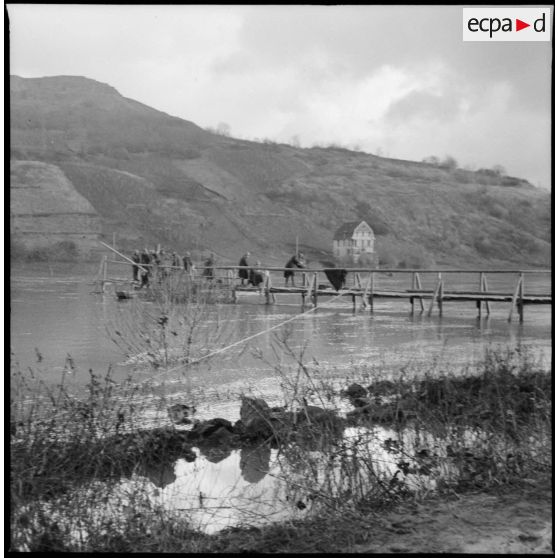 Des sapeurs du génie de la 3e armée construisent une passerelle de bois sur la Moselle.