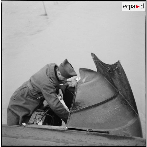 Un soldat de la 3e armée se penche sur le moteur d'un véhicule en panne.