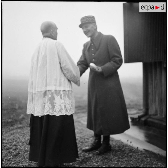 Un général de la 3e armée serre la main du prêtre catholique.