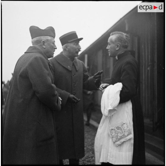 Deux officiers de la 3e armée discutent avec un prêtre catholique.