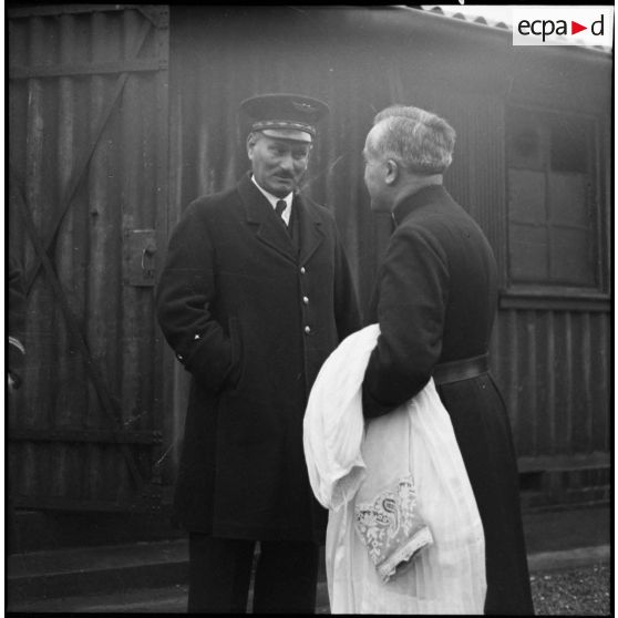 Un général de brigade aérienne discute avec un prêtre catholique.