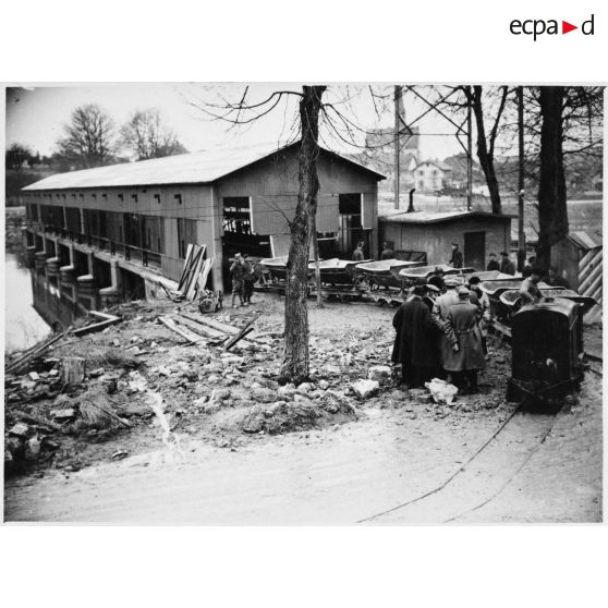 Photographie de groupe des personnalités politiques près d'une voie ferrée étroite.