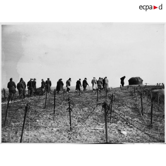 Photographie de groupe des personnalités politiques près d'une cloche métallique.