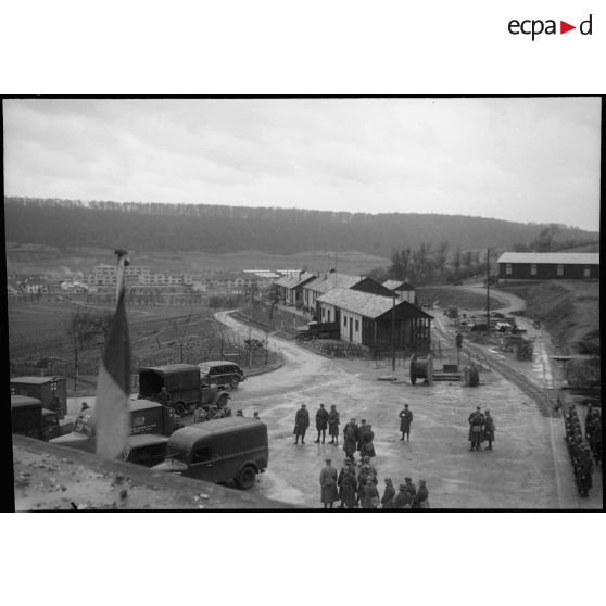 Plan général en plongée de camionettes Renault de l'association des gueules cassées devant l'entrée des munitions du Hackenberg.
