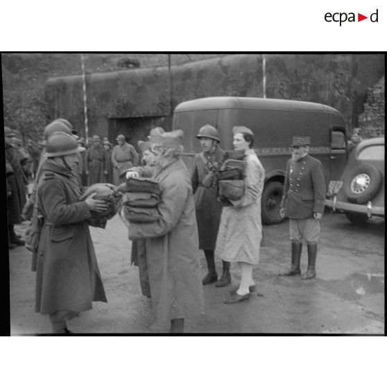 L'association des gueules cassées distribue des effets à des soldats dans le secteur de la 3e armée.