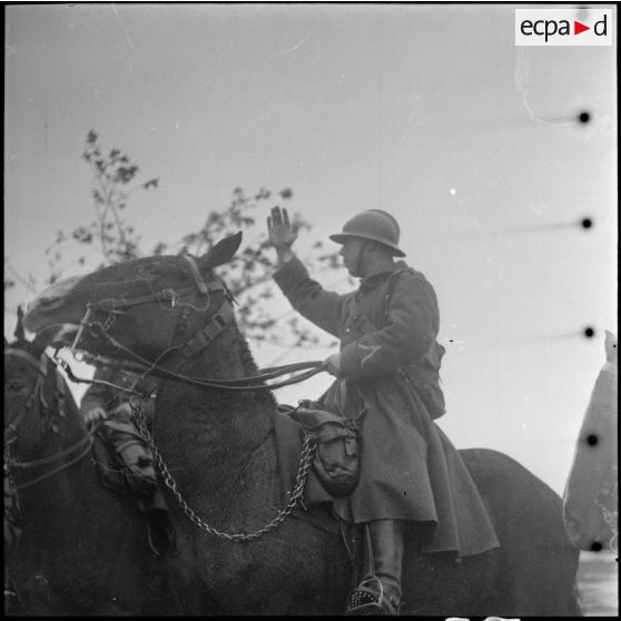Vue en contre-plongée d'un sous-officier d'une unité d'artillerie de la 42e DI et de sa monture.