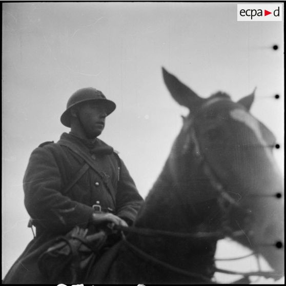 Vue en contre-plongée d'un sous-officier d'une unité d'artillerie de la 42e DI et de sa monture.
