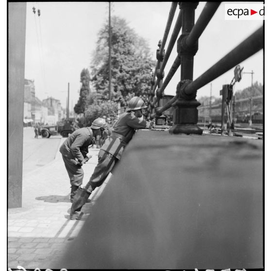 Dans une rue de Esch-sur-Alzette des soldats de la 3e DLC sont postés derrière un muret.
