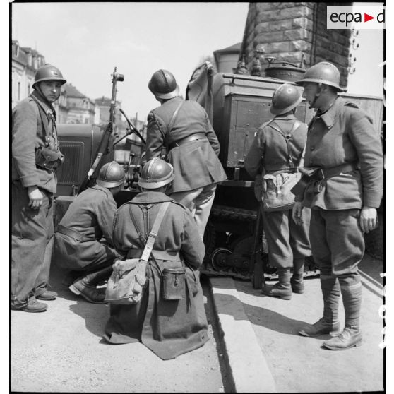 Des soldats de la 3e DLC se tiennent postés derrière un semi-chenillé dans une rue de Esch-sur-Alzette.