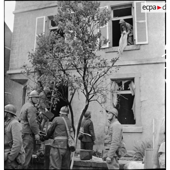 Des soldats de la 3e armée évacuent les meubles d'une maison.
