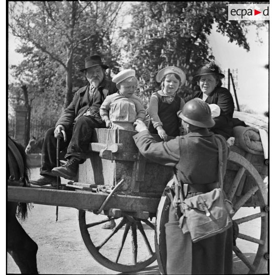 Des réfugiés sont photographiés dans une carriole.