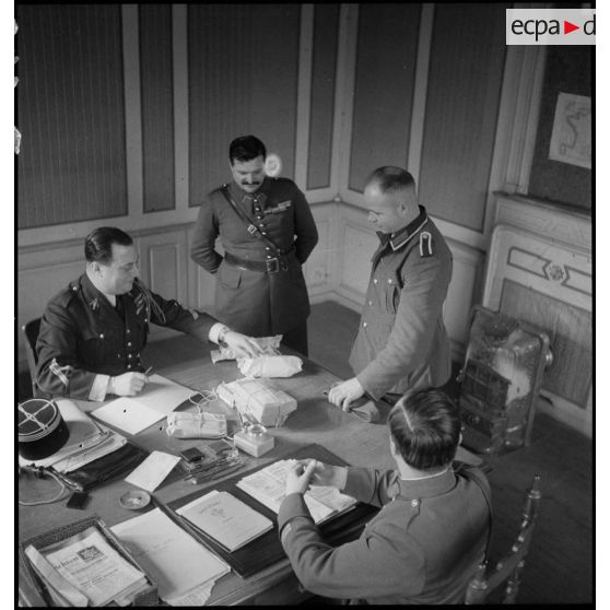 Des officiers et des sous-officiers français interrogent un prisonnier allemand dans un bureau.