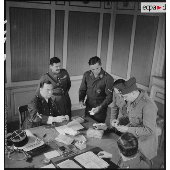 Des officiers et des sous-officiers français interrogent un prisonnier allemand dans un bureau.