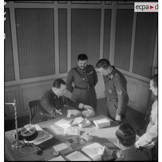 Des officiers et des sous-officiers français interrogent un prisonnier allemand dans un bureau.