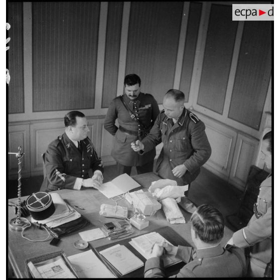 Des officiers et des sous-officiers français interrogent un prisonnier allemand dans un bureau.
