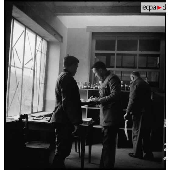 Des officiers et des sous-officiers français interrogent un prisonnier allemand dans un bureau.