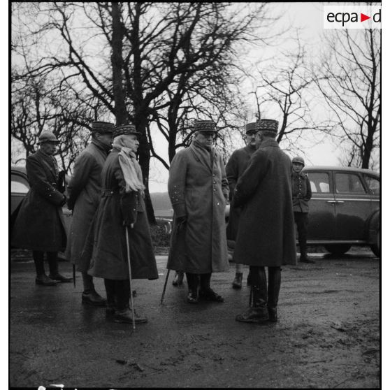 Des officiers généraux, dont les généraux Georges et Réquin, discutent sur le bord d'une route.