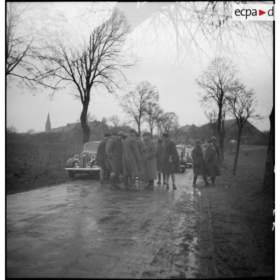 Des officiers généraux, dont les généraux Georges et Réquin, discutent sur le bord d'une route.