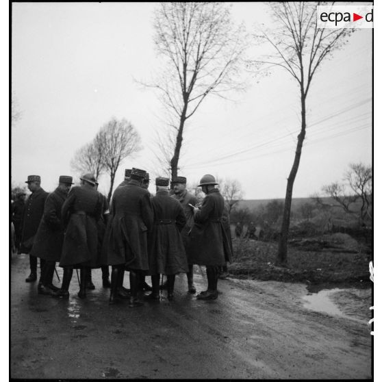 Des officiers généraux, dont les généraux Georges et Réquin, sont photographiés sur le bord d'une route.