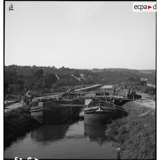 Des chars Renault R35 de la 4e armée traversent un canal sur un pont de péniches.