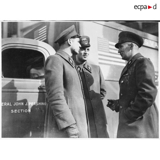 A Fenétrange, un officier américain s'entretient avec deux conducteurs d'ambulances de la Section sanitaire de volontaires américains n°1 (SSVA) John J. Pershing.
