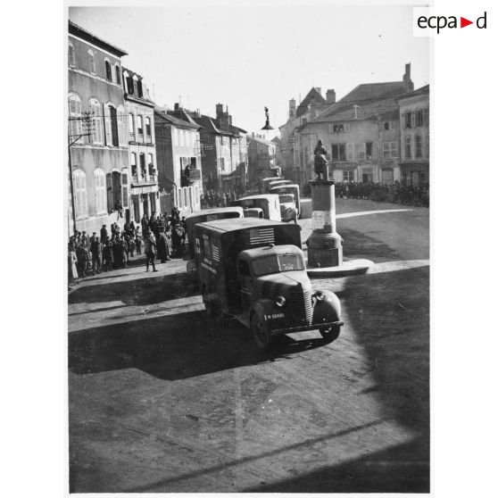 Les ambulances Chevrolet de la 1re section sanitaire de volontaires américains (SSVA), qui porte le nom de general John J. Pershing, arrivent sur la place Jeanne d'Arc à Vic-sur-Seille pour une présentation aux autorités.