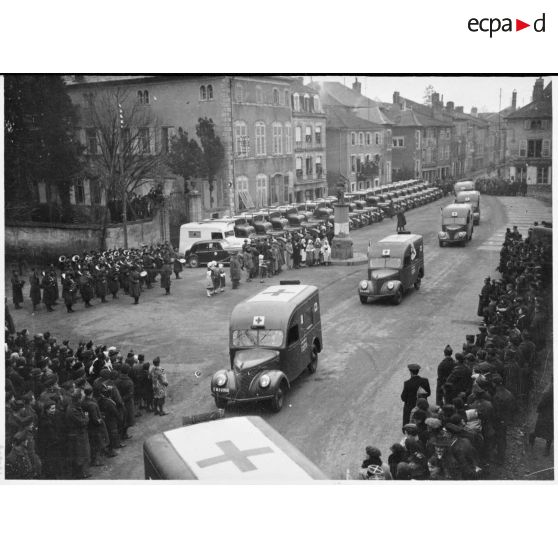 Défilé des ambulances Matford de la SSBM (société de secours aux blessés militaires) sur la place de Vic-sur-Seille.