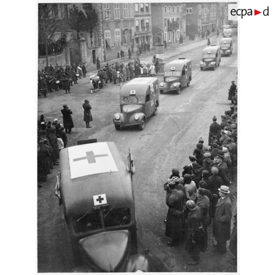 Défilé des ambulances Matford de la SSBM (société de secours aux blessés militaires) sur la place de Vic-sur-Seille.