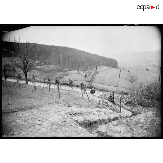 Des fantassins d'une section de mitrailleuses marchent sur une route dans le secteur de la 4e armée.