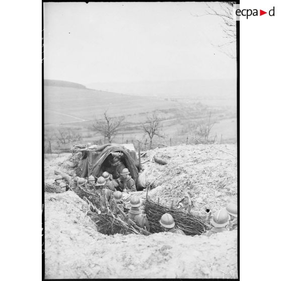 Des fantassins d'une section de mitrailleuses marchent dans un boyau dans le secteur de la 4e armée.