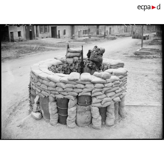 Un soldat de la 4e armée sert un FM 24/29 sur affût antiaérien protégé par des sacs de sable.