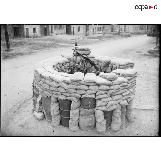 Un soldat de la 4e armée sert un FM 24/29 sur affût antiaérien protégé par des sacs de sable.