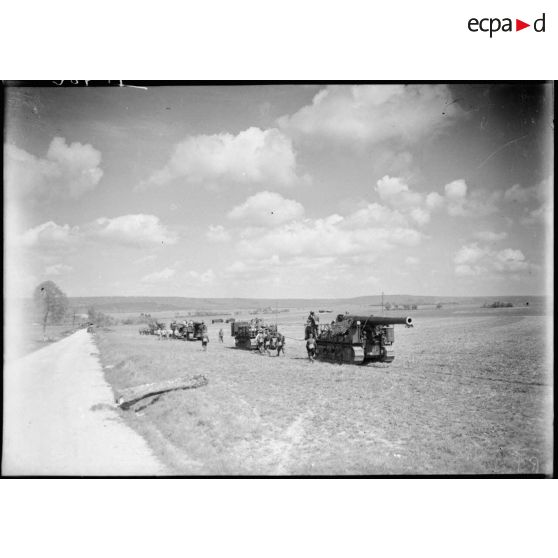 Des 194 GPF du 184e RA sur affût chenillé Saint-Chamond se déplacent dans un champ au bord d'une route.