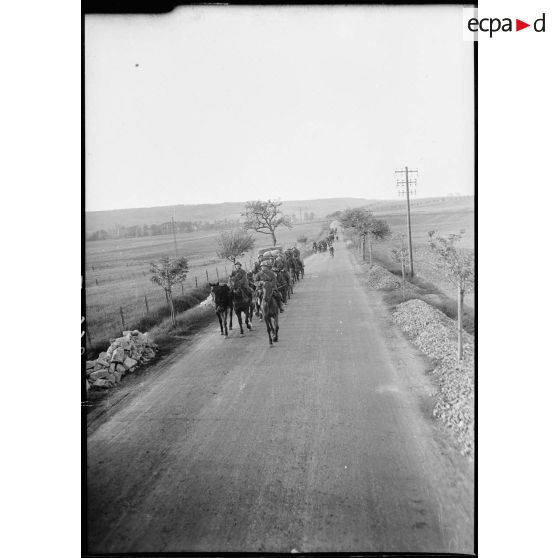 Plan général de voitures hippomobiles de la 4e armée qui circulent chargées sur une route de Lorraine.