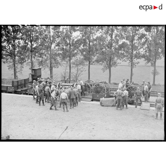 Sur le quai d'une gare dans le secteur de la 4e armée, chargement de 75 mm modèle 1897 sur un train.